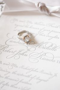 diamond wedding ring sitting on invitation