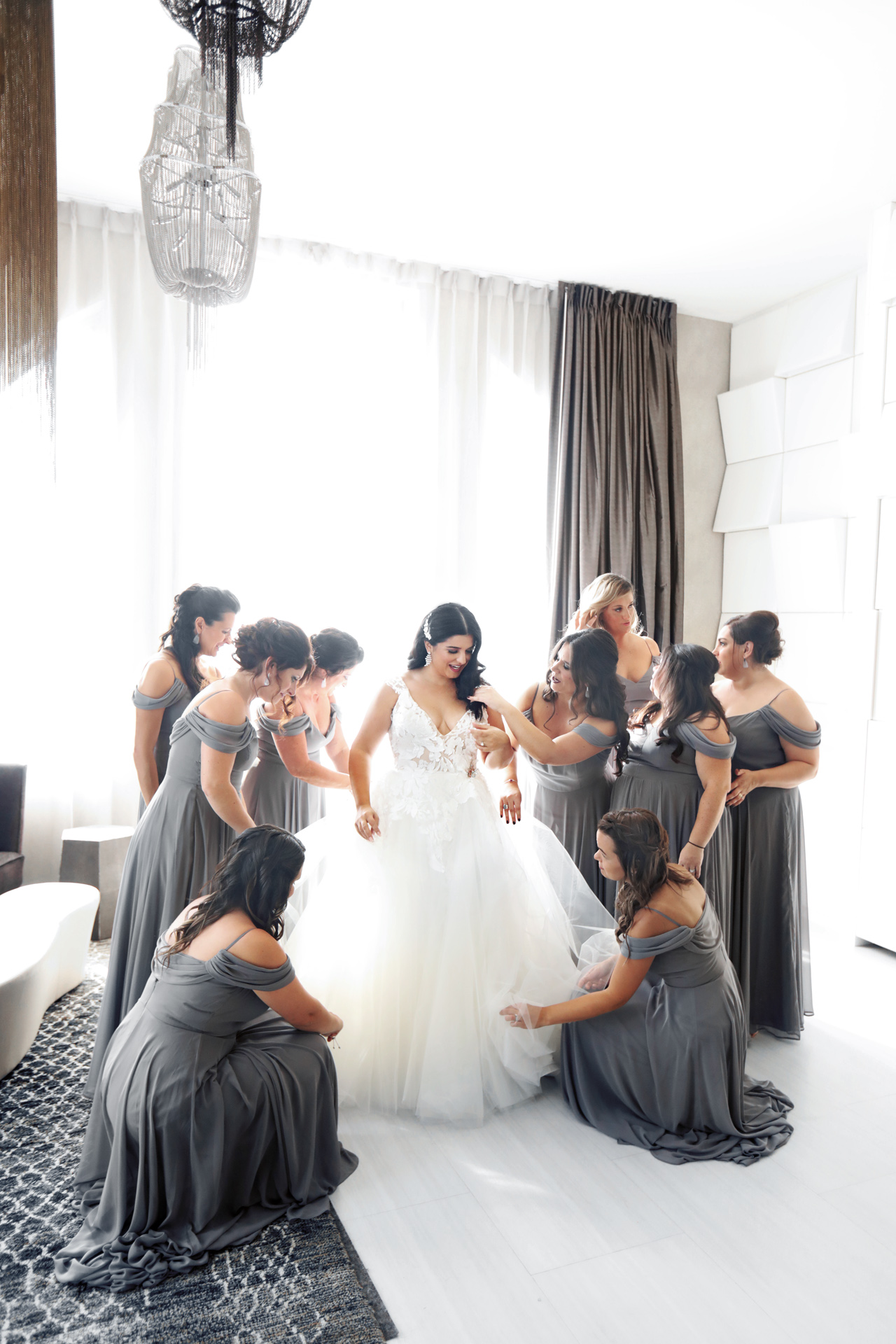 bridesmaids assist the bride before the wedding ceremony
