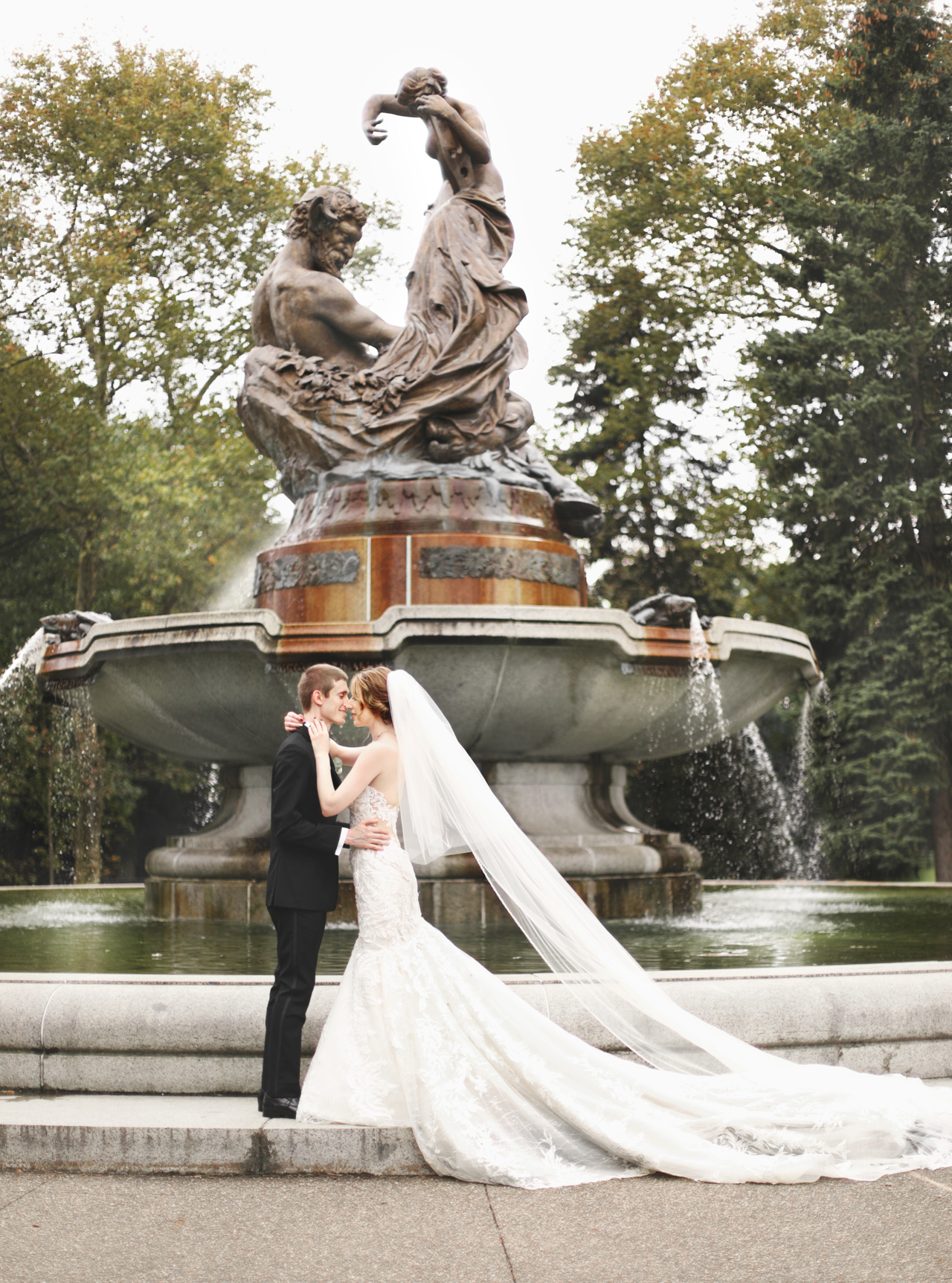 bride and groom standing by fountain in pittsburgh, pa