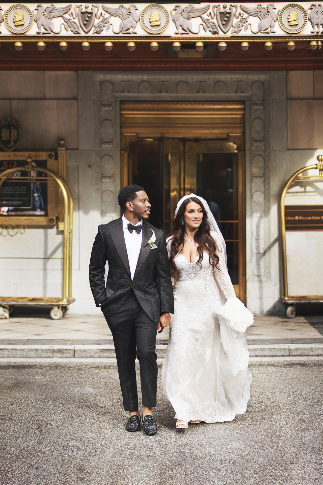 A newlywed couple exit the Omni William Penn Hotel in Pittsburgh, PA