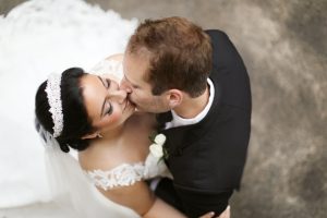 An overhead photograph of a bride and groom kissing